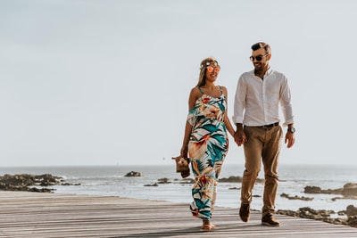 A couple walking at the beach during the day
